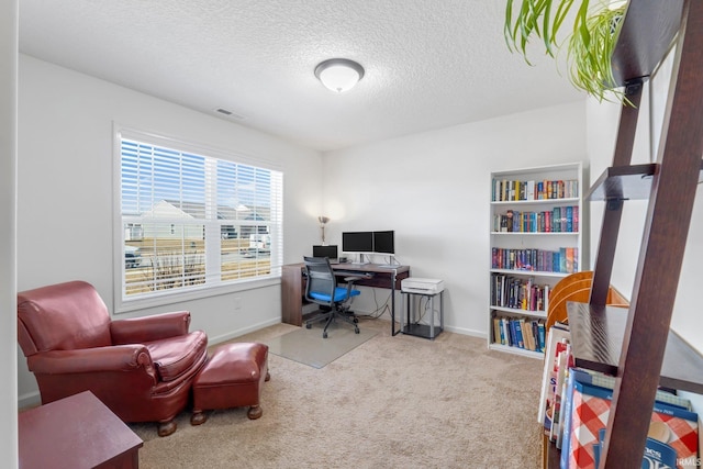 carpeted office space with visible vents, a textured ceiling, and baseboards