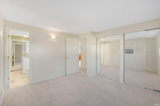 unfurnished bedroom featuring baseboards, connected bathroom, two closets, and carpet