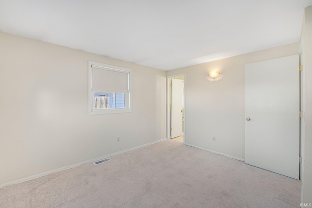 carpeted empty room featuring visible vents and baseboards