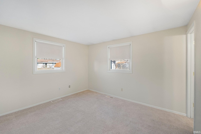 spare room with visible vents, carpet floors, and baseboards