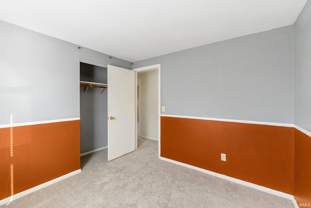 unfurnished bedroom featuring baseboards, a closet, and carpet floors