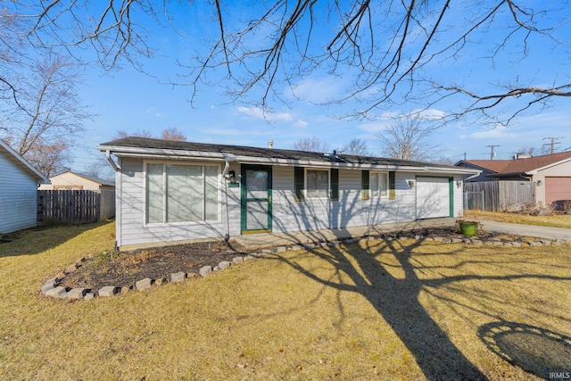 rear view of property featuring concrete driveway, fence, a garage, and a lawn