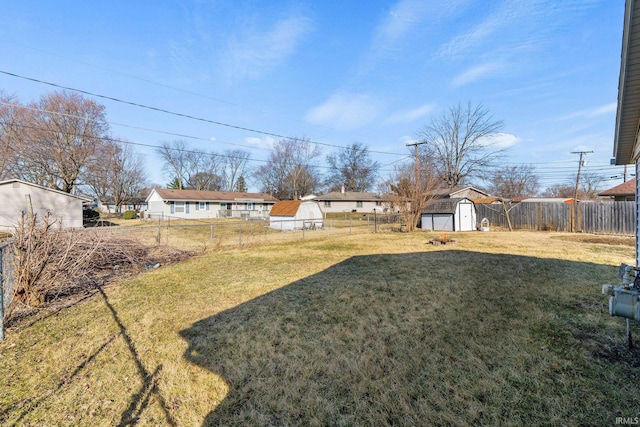 view of yard featuring a fenced backyard, a storage shed, and an outdoor structure