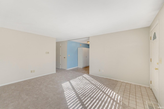 unfurnished room with light colored carpet and baseboards