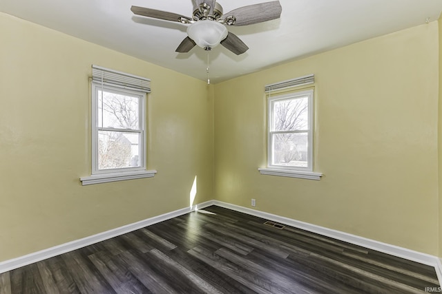 unfurnished room featuring ceiling fan, visible vents, baseboards, and dark wood finished floors