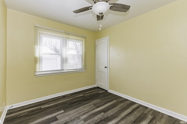 unfurnished room with ceiling fan, visible vents, baseboards, and dark wood-style floors