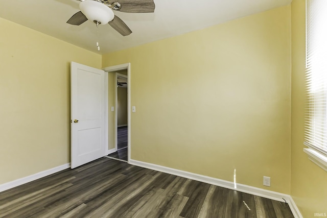 empty room with ceiling fan, dark wood-type flooring, and baseboards