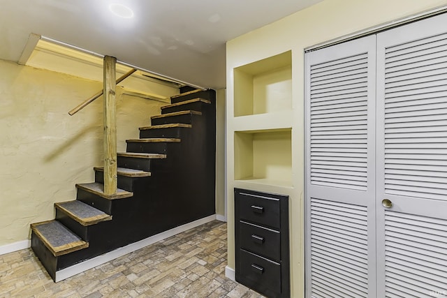 stairs featuring brick floor and baseboards