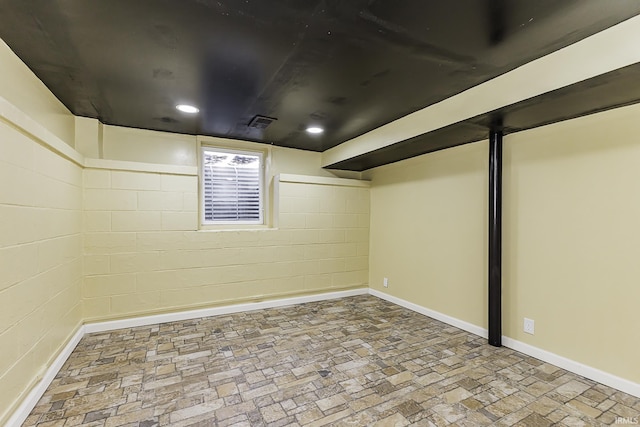 finished below grade area featuring recessed lighting, visible vents, baseboards, and concrete block wall