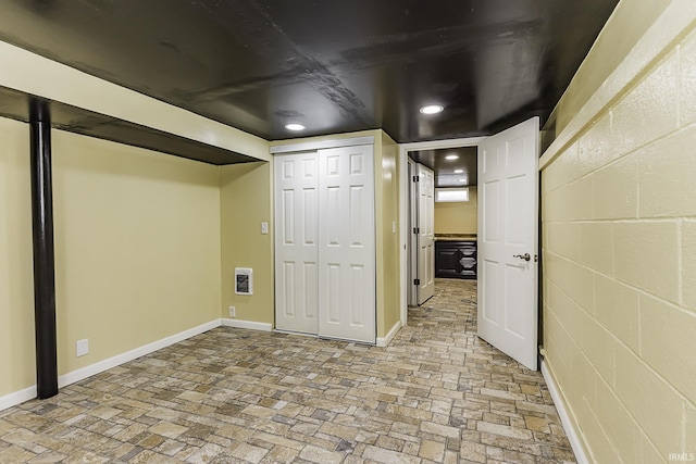 finished basement featuring recessed lighting, concrete block wall, and baseboards