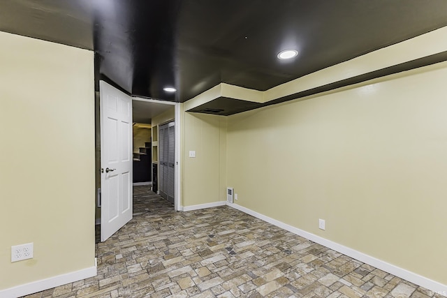 finished basement with visible vents, recessed lighting, baseboards, and stone finish flooring