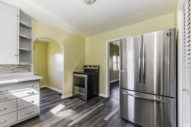 kitchen featuring open shelves, decorative backsplash, appliances with stainless steel finishes, arched walkways, and dark wood-style flooring