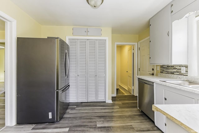 kitchen with dark wood finished floors, light countertops, backsplash, and stainless steel appliances