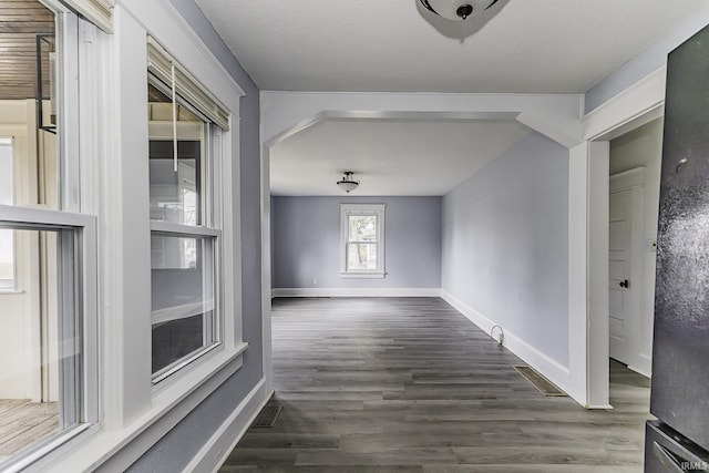 interior space with visible vents, a textured ceiling, baseboards, and dark wood-style flooring