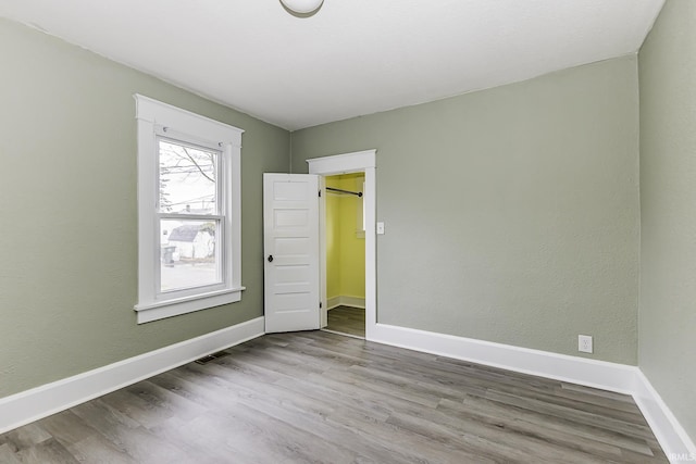 empty room featuring visible vents, baseboards, and wood finished floors