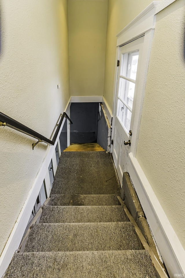 staircase featuring a textured wall