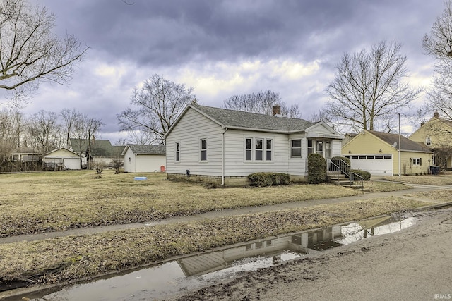 view of front of house with an outbuilding, a garage, and a chimney