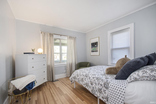 bedroom with crown molding, baseboards, and light wood-type flooring