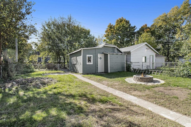 view of yard featuring an outbuilding, a fenced backyard, and an outdoor fire pit