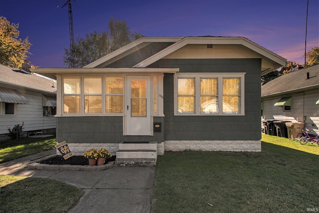 view of front of house with entry steps and a front lawn