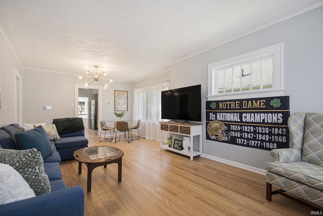 living room with light wood finished floors, crown molding, baseboards, a chandelier, and a textured ceiling