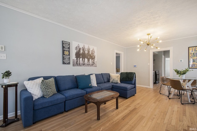 living room featuring baseboards, a textured ceiling, crown molding, a notable chandelier, and light wood-type flooring