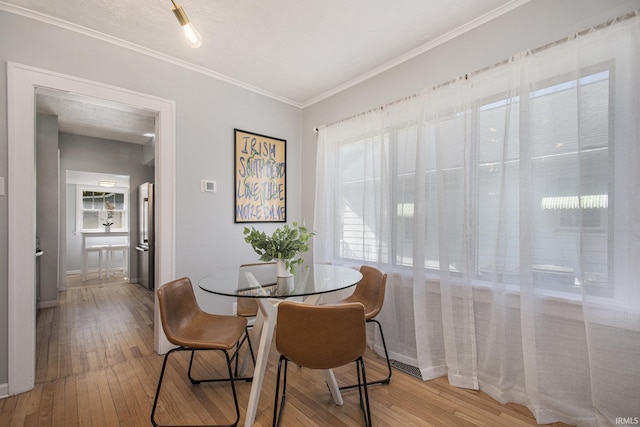 dining area featuring crown molding and wood-type flooring