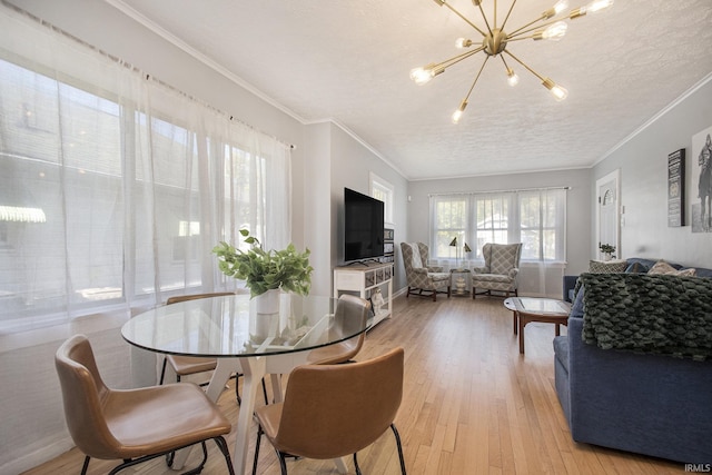 dining room with a textured ceiling, an inviting chandelier, light wood-style flooring, and crown molding