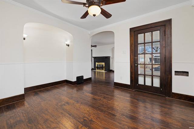 unfurnished room featuring crown molding, wood finished floors, arched walkways, and ceiling fan