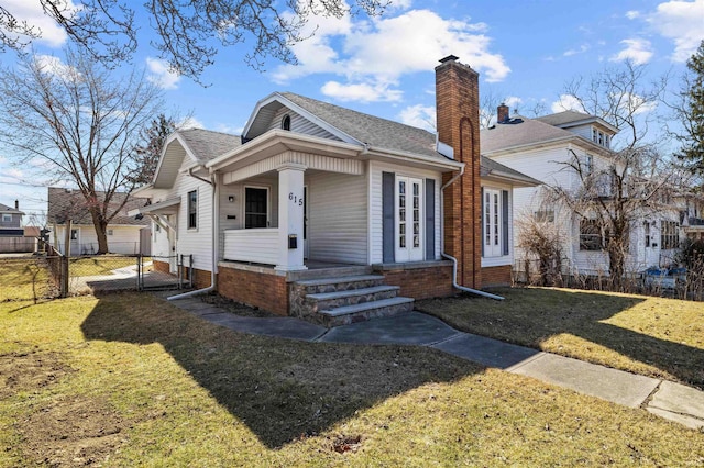 exterior space with a gate, a lawn, a chimney, and fence