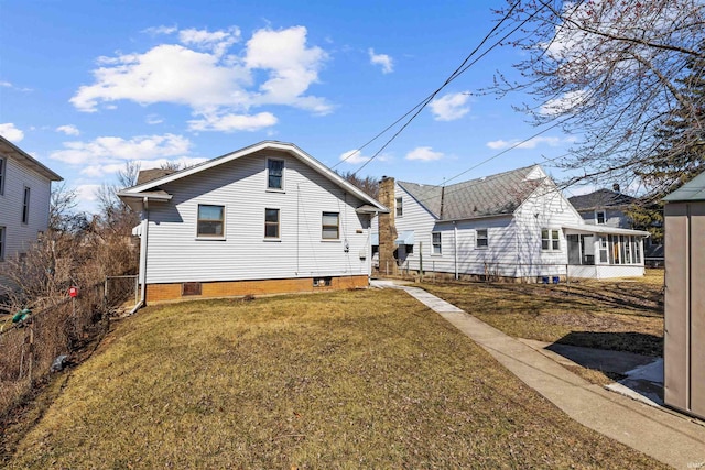 back of house featuring a lawn, fence, and a sunroom