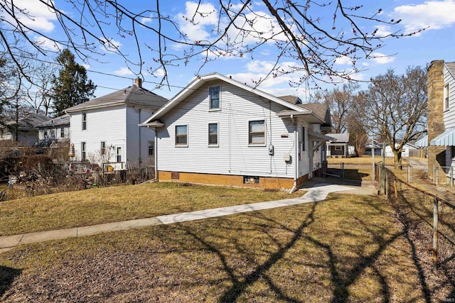 view of property exterior with a lawn and fence