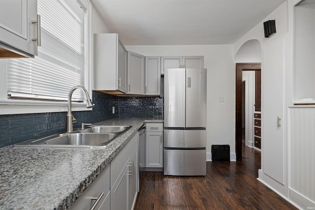 kitchen with appliances with stainless steel finishes, dark wood-type flooring, gray cabinetry, and a sink