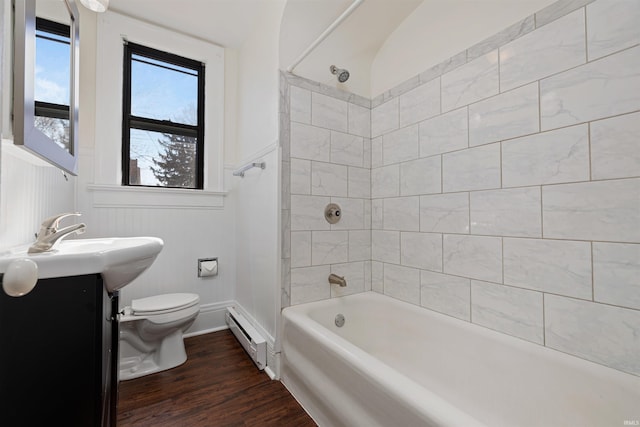 bathroom featuring a wainscoted wall, toilet, wood finished floors, tub / shower combination, and a baseboard radiator