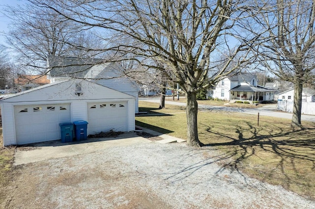 view of yard featuring a residential view, a detached garage, and an outdoor structure