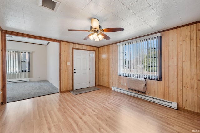 foyer entrance with wood finished floors, wood walls, and a baseboard radiator