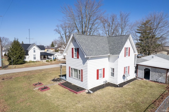 view of front of home featuring roof with shingles and a front yard