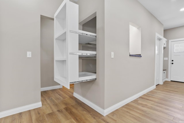 hallway featuring light wood-style flooring, recessed lighting, and baseboards