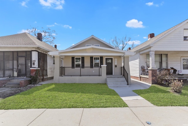 view of front of house featuring brick siding, a porch, and a front lawn