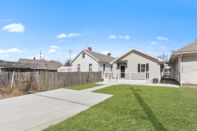 back of house featuring a yard, a patio, and fence