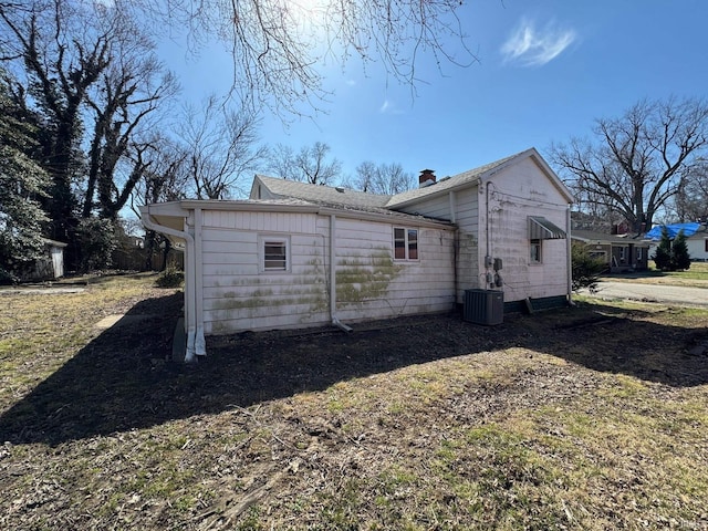 back of property featuring cooling unit and a chimney