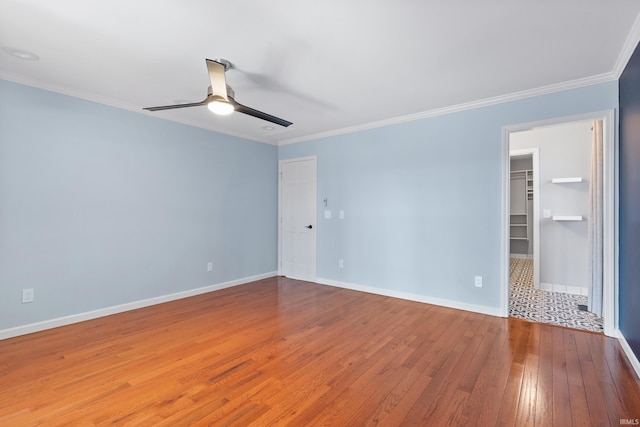 interior space featuring ornamental molding, baseboards, a ceiling fan, and hardwood / wood-style flooring