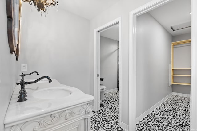 bathroom featuring tile patterned floors, baseboards, toilet, and vanity