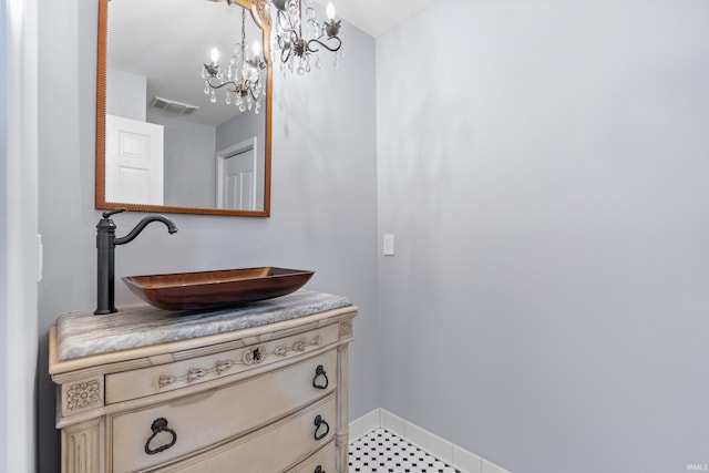 bathroom featuring visible vents, baseboards, a chandelier, and vanity