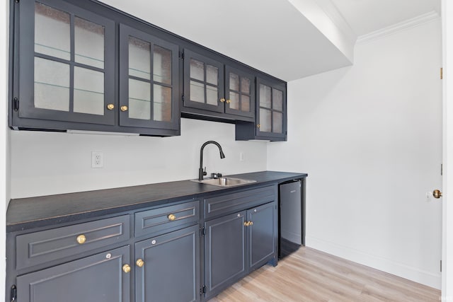 bar featuring dishwashing machine, baseboards, a sink, crown molding, and light wood-type flooring