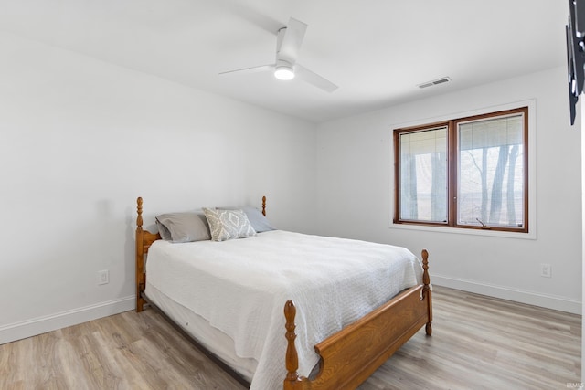 bedroom featuring visible vents, light wood-style flooring, a ceiling fan, and baseboards