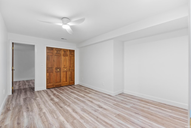 unfurnished bedroom featuring a closet, baseboards, and light wood-style flooring