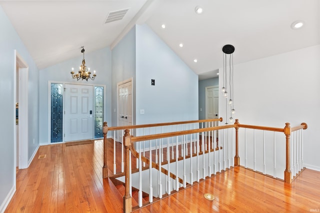 entryway featuring visible vents, high vaulted ceiling, light wood-style flooring, an inviting chandelier, and baseboards