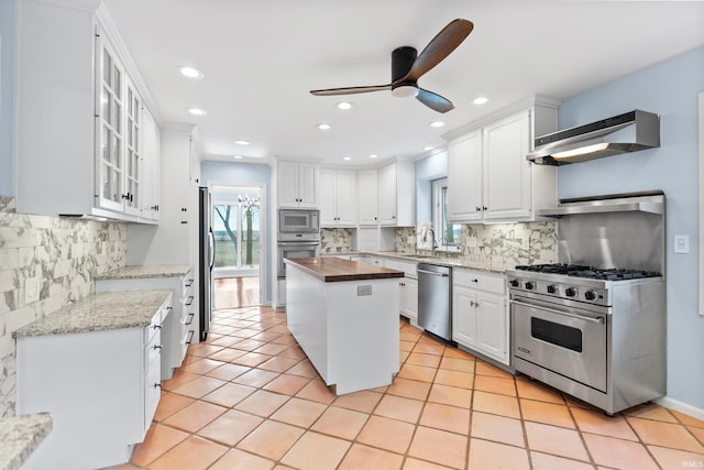 kitchen featuring white cabinetry, stainless steel appliances, exhaust hood, light tile patterned flooring, and ceiling fan