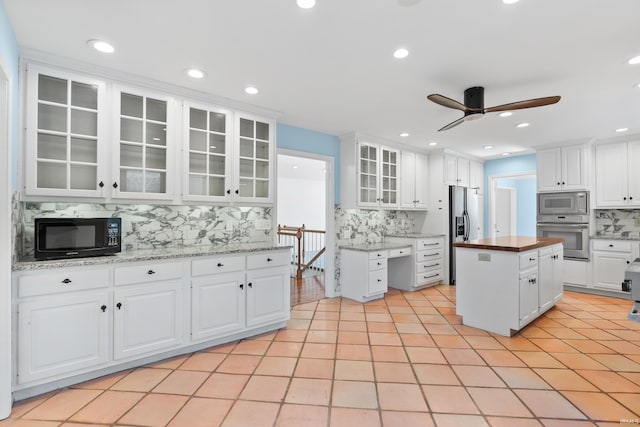 kitchen featuring ceiling fan, decorative backsplash, white cabinets, and stainless steel appliances